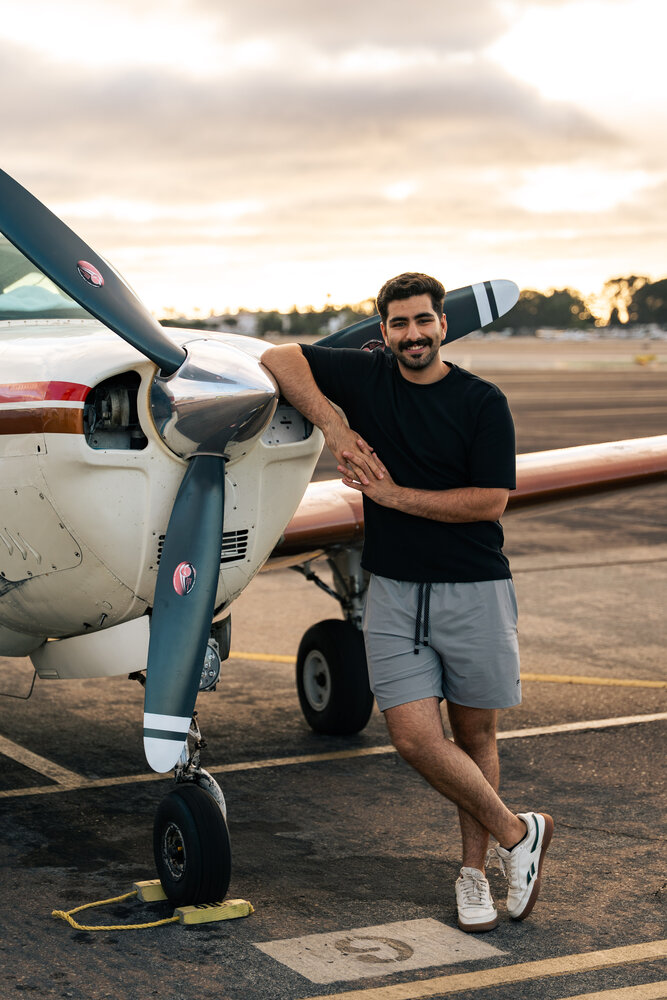 Mohammed Alhadher, FAA-certified flight instructor, standing beside a training aircraft