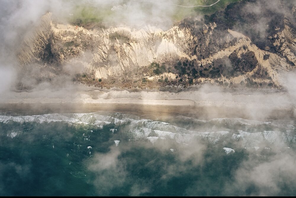 Aerial view of the Southern California coastline through clouds